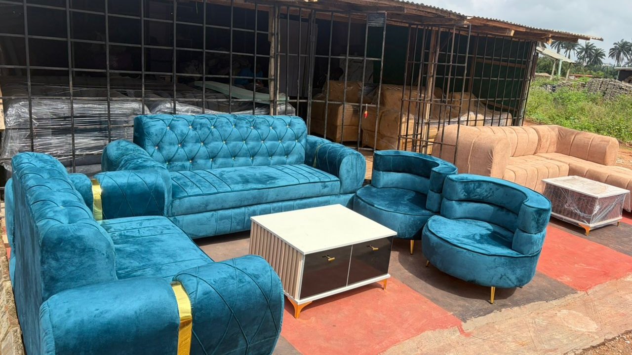 The Seunscope workshop in Osogbo, with a finished velvet sofa set and centre table standing outside it