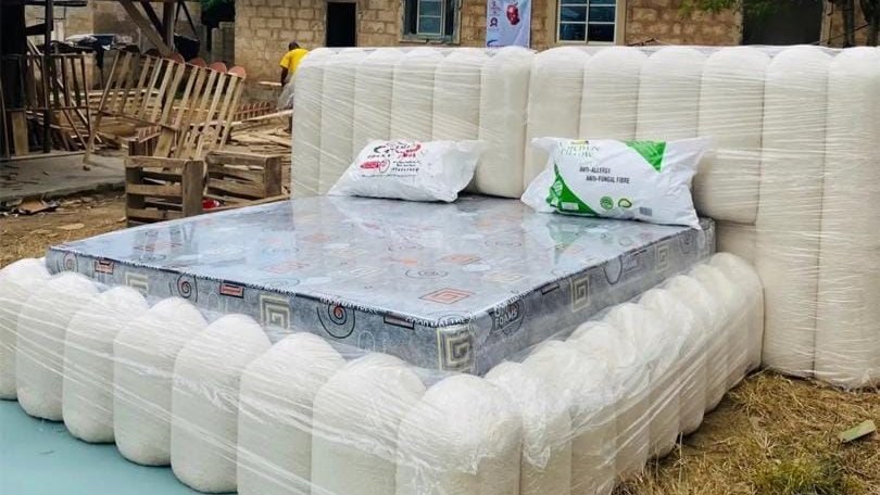 A finished upholstered bed frame, wrapped and waiting outside the Seunscope workshop in Osogbo